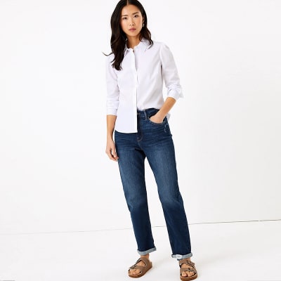 Woman wearing blue boyfriend jeans and white blouse