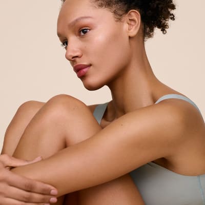 Woman with glowing skin wearing grey bra