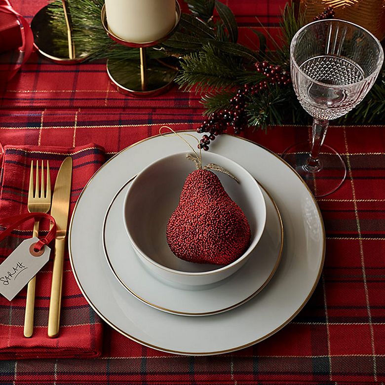 Christmas table set with tartan tablecloth, white and gold crockery and gold cutlery