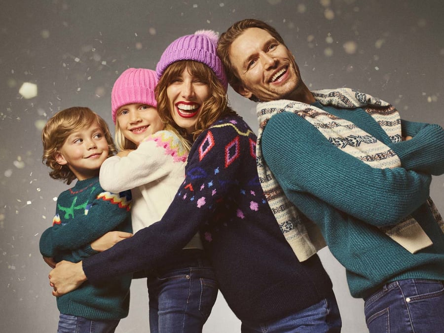Family wearing a selection of M&S Christmas jumpers