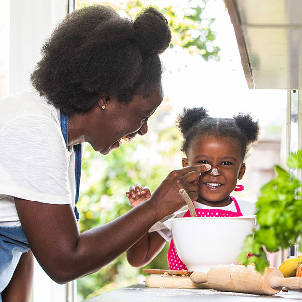 An adult and child having fun baking