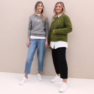 M&S Insider Emma wearing grey cashmere jumper, white T-shirt, blue barrel-leg jeans and white side-detail trainers; M&S Insider Jenny wearing green cable-knit jumper, white shirt, black boyfriend jeans and white trainers