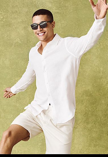 Man wearing white linen shirt, white shorts and sunglasses