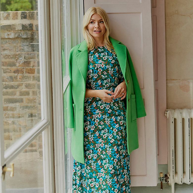 Holly Willoughby wearing blue floral-print dress and green coat. Shop women’s new in