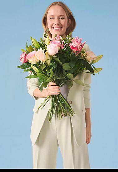 Woman holding a bouquet of Mother’s Day flowers. Shop Mother’s Day flowers and plants.