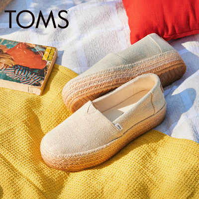 Cream espadrilles by Toms on a beach towel. Shop Toms at M&S. 