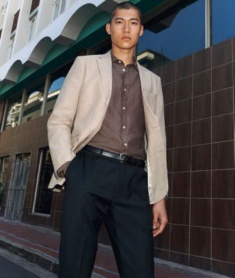 Man wearing beige blazer, brown shirt, black belt and black trousers by Charles Tyrwhitt. Shop Charles Tyrwhitt