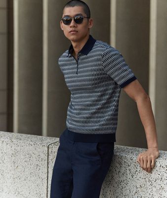 Man wearing navy striped polo shirt from the spring campaign collection. Shop new-in menswear 