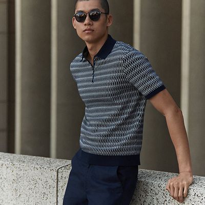 Man wearing navy striped polo shirt from the spring campaign collection. Shop new-in menswear