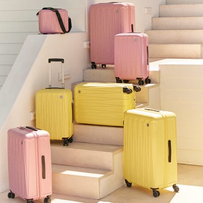 A group of pink and yellow suitcases. Shop luggage 