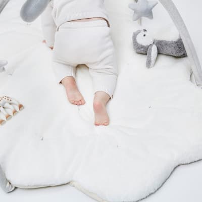 Baby wearing knitted leggings on playmat. Shop baby
