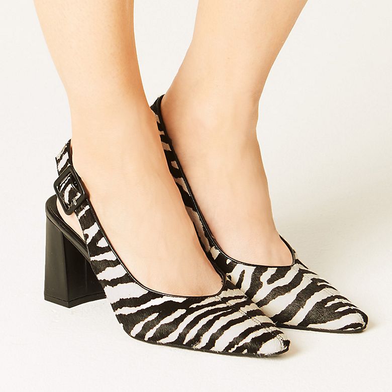 Woman wearing black and white zebra-print sling-back shoes