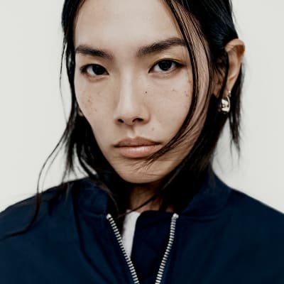 Woman wearing capsule wardrobe staples including a bomber jacket. Shop capsule clothing. 