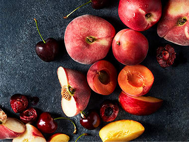 Whole and halved stone fruits including cherries, peaches and nectarines