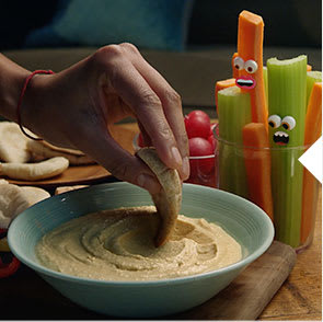 A bowl of velvet houmous with our crudities characters