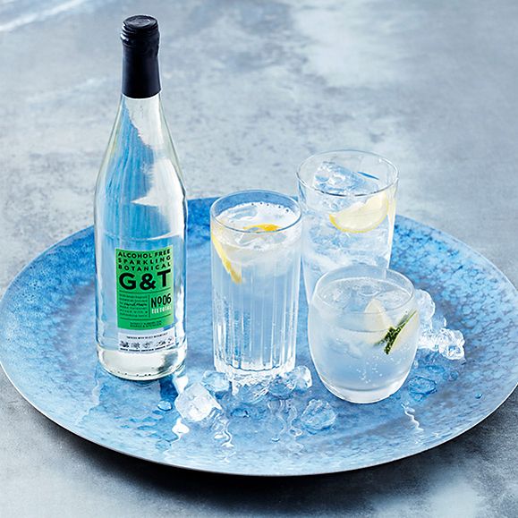 Alcohol free gin and tonic with glasses on a blue tray
