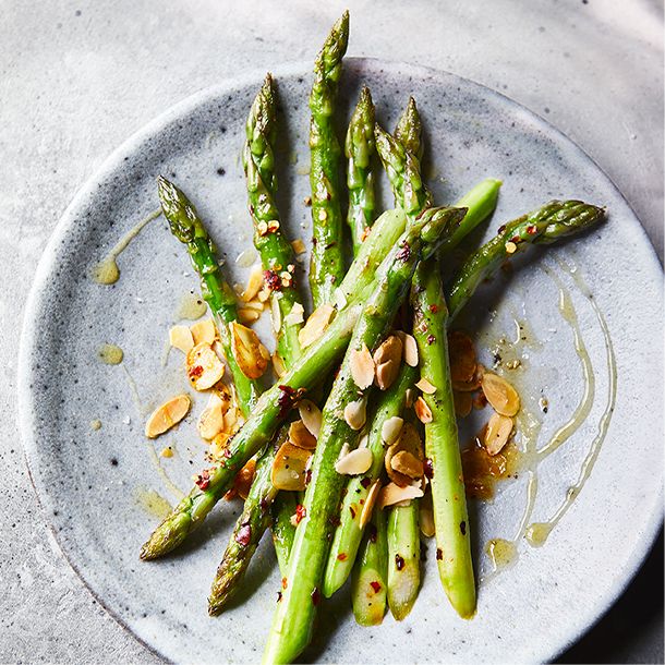 Asparagus spears dressed in oil and almond flakes