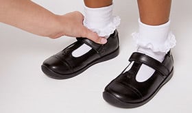 Adult checking the ankle area of child's shoe