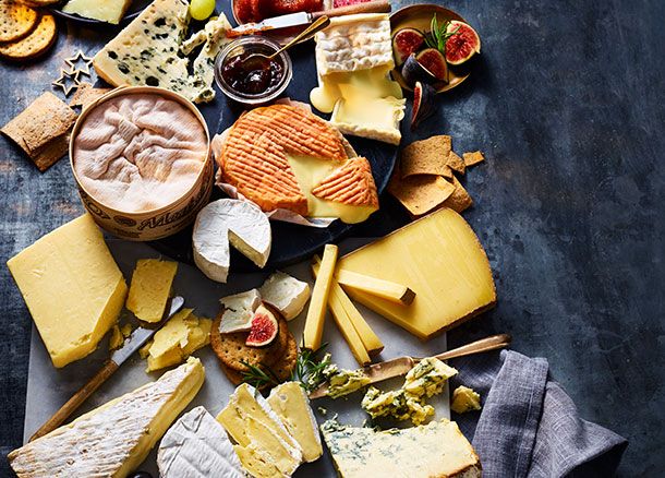 A cheeseboard featuring a selection of cheeses, crackers and chutney