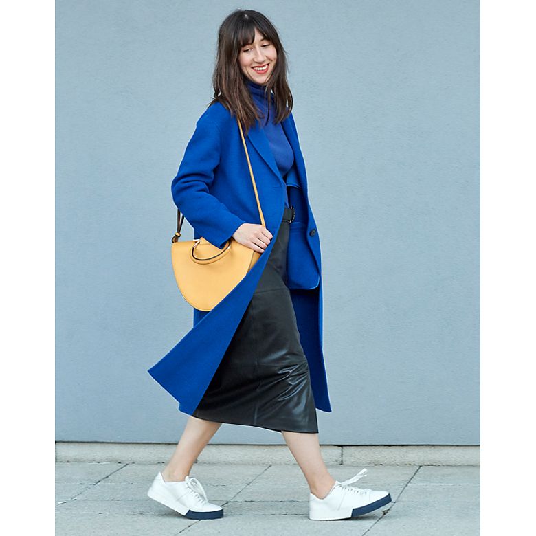 Woman wears coat, skirt and polo neck from Holly’s Must-Haves collection