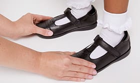 Adult checking the width of child's shoe