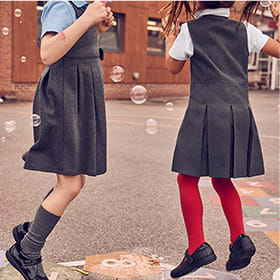 Girls wearing M&S crease-resistant pinafores
