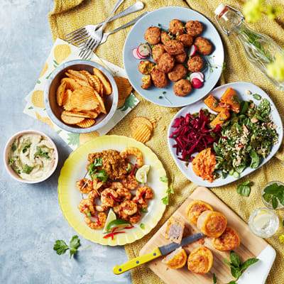 A spread of picnic food including crisps, pork pies and houmous