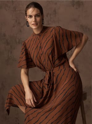 Model wears a brown tiger-print midi dress