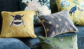 Patterned scatter cushions on a teal velvet sofa