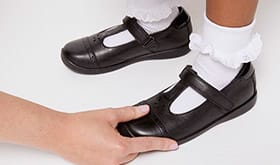 Adult checking the depth of child's shoe
