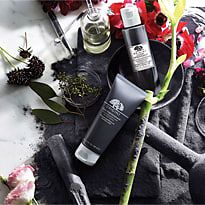 Origins Clear Improvement range surrounded by charcoal and flowers