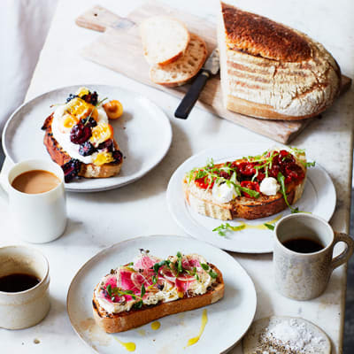 A loaf of sourdough with different toppings and coffee