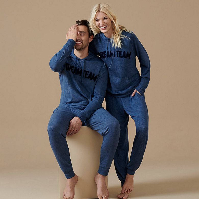 Man and woman wearing matching slogan blue loungewear sets