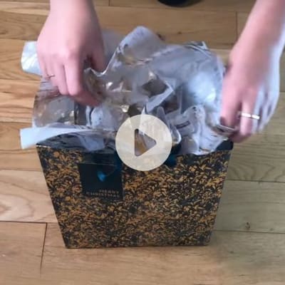 Woman showing how to use tissue paper in a gift bag