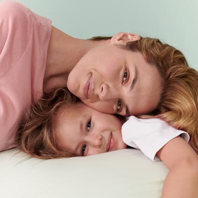 Woman wearing a pink top and girl wearing a white top