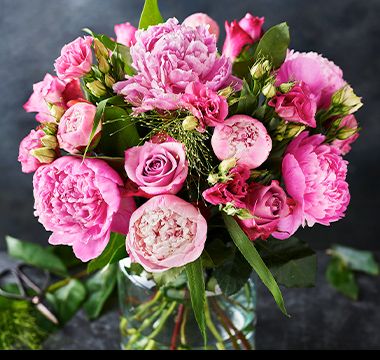 A vase filled with pink peonies