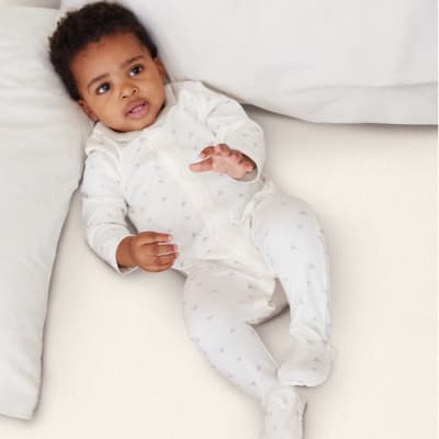 Baby wearing white M&S sleepsuit