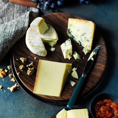 A cheeseboard with blue cheese, brie and cheddar