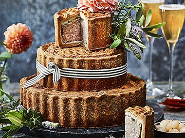 Tiered wedding pork pie with fresh flowers and ribbon