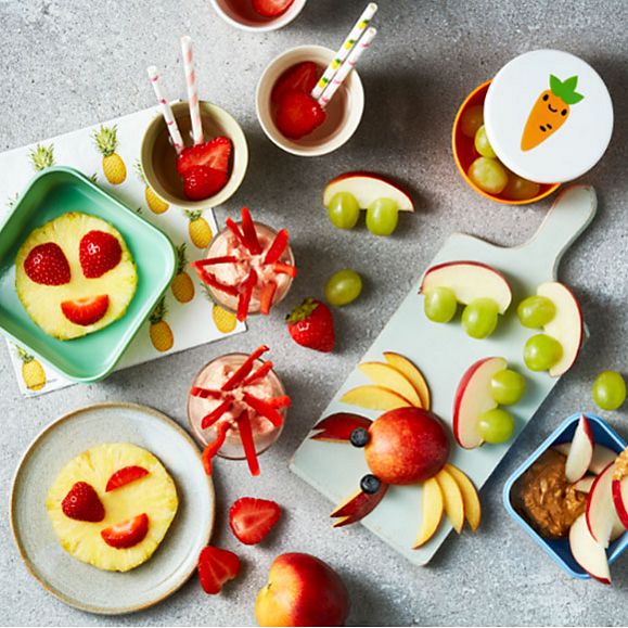 A selection of child-friendly snacks including pineapple emojis and fruity water