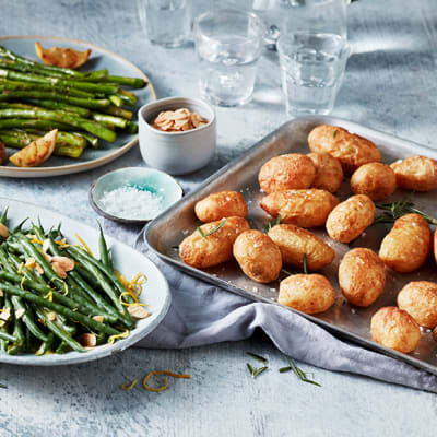 Steamed Boston beans with toasted almonds and a tray of golden roasted Jersey potatoes
