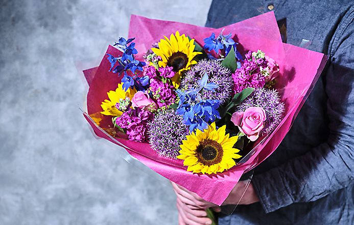 A Man Holds Bunch Of Bright Spring Flowers