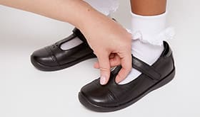 Adult checking the depth of child's shoe