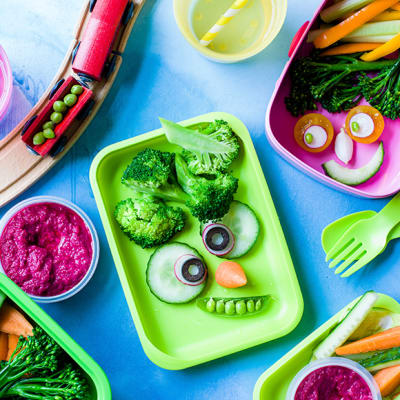 Kids’ lunchboxes with vegetables arranged in monster face shapes