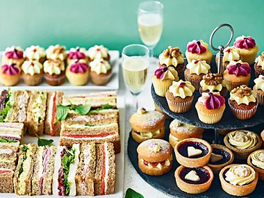 Spread of sandwiches, cakes and champagne
