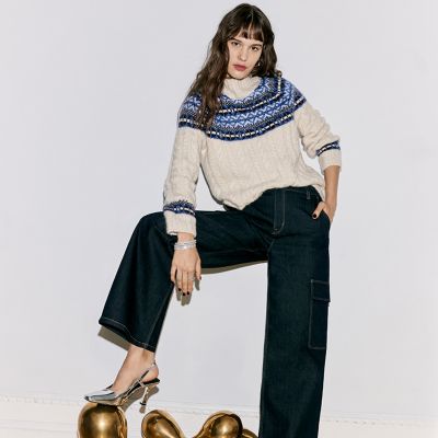 Woman wearing cream Fair Isle jumper and indigo cargo jeans. Shop knitwear