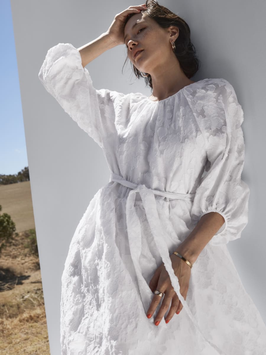 Woman wearing white belted dress. Shop occasionwear